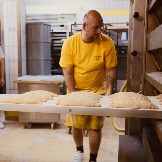 Über uns - In der Backstube der Teig kommt in den Ofen