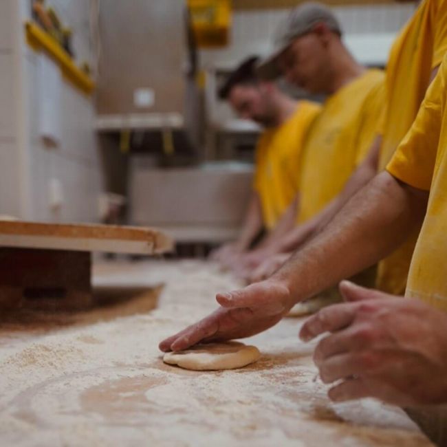 Über uns - In der Backstube am Teig formen