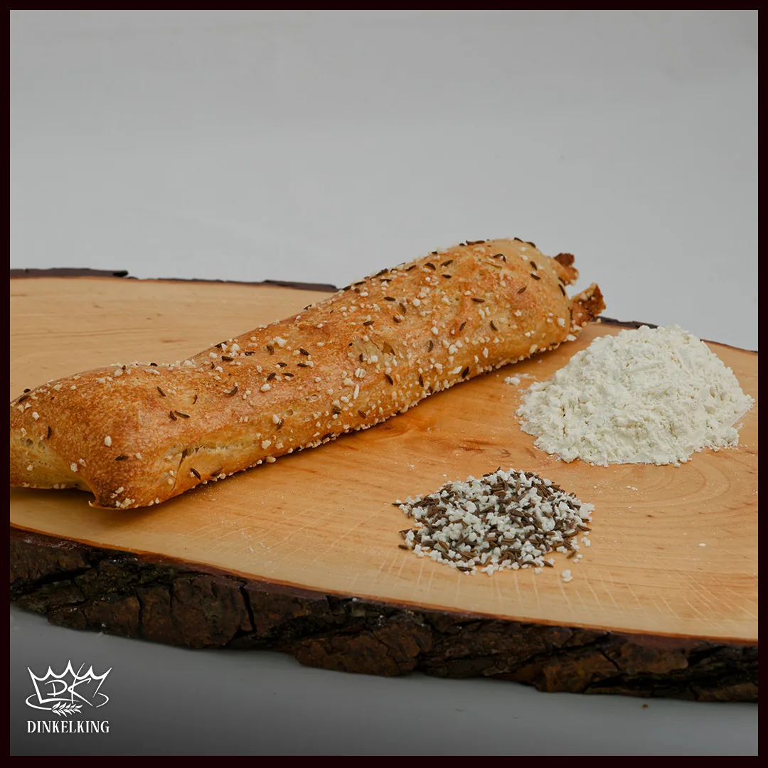 Frisch gebackene Dinkel-Seele Classic mit Kümmel und Salz auf einem Holzbrett
